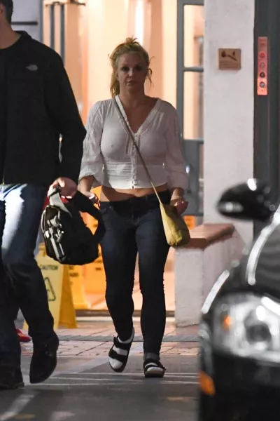 Britney zokniban, papucsban és melltartó nélkül viselt laza ingben távozik egy egészségügyi intézményből testőre kíséretében Los Angeles-ben - adta hírül egy képügynökség. 